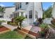 Landscaped backyard with a brick patio, mulched garden beds, and a white picket fence at 109 Grinnell Pl, Celebration, FL 34747