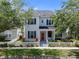 Charming home with a red front door, a white picket fence, well-maintained lawn, and lush landscaping at 109 Grinnell Pl, Celebration, FL 34747