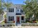 Charming two-story home featuring a red front door, picket fence, and well-manicured landscaping at 109 Grinnell Pl, Celebration, FL 34747