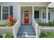 Inviting front porch with steps leading up to a vibrant red door and neat landscaping at 109 Grinnell Pl, Celebration, FL 34747