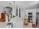 Open kitchen with white cabinets, quartz counters, stainless appliances, and adjacent staircase at 109 Grinnell Pl, Celebration, FL 34747