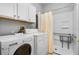 Bright laundry room with modern washer and dryer units and built in shower at 109 Grinnell Pl, Celebration, FL 34747