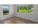 Bedroom featuring wood-look tile floor and windows showcasing the lush greenery outside at 113 Tangelo Ct, Maitland, FL 32751