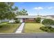 Charming single-story home featuring a modern facade, lush landscaping, and a welcoming pink front door at 113 Tangelo Ct, Maitland, FL 32751