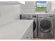 This bright laundry room features front loading washer and dryer, counter space, and a window at 113 Tangelo Ct, Maitland, FL 32751
