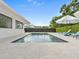 Backyard with a pool, privacy hedge, lounge chairs with umbrellas, and a stone patio at 113 Tangelo Ct, Maitland, FL 32751