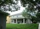 Spacious backyard features a covered patio with furniture, a lush lawn, and mature trees at 14522 Old Thicket Trace, Winter Garden, FL 34787