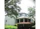 Inviting two-story home showcases a covered porch with stately columns and lush, colorful landscaping at 14522 Old Thicket Trace, Winter Garden, FL 34787