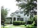 Charming two-story home features a covered porch, manicured landscaping, and classic architectural details at 14522 Old Thicket Trace, Winter Garden, FL 34787