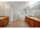 Bright bathroom with tile floors, wooden cabinets, double sinks, and separate shower and tub at 14522 Old Thicket Trace, Winter Garden, FL 34787