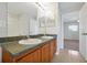 Bathroom featuring double sinks, vanity, and tile flooring with an open doorway at 14522 Old Thicket Trace, Winter Garden, FL 34787