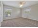 Bedroom featuring neutral colored walls and flooring with a ceiling fan and two windows at 14522 Old Thicket Trace, Winter Garden, FL 34787