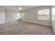 Spacious bedroom with two windows bringing in natural light and neutral colored walls and flooring at 14522 Old Thicket Trace, Winter Garden, FL 34787