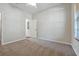A bedroom with neutral carpet, walls, and trim, with a window and closet door at 14522 Old Thicket Trace, Winter Garden, FL 34787