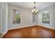 Bright dining room with wood floors, natural light from windows and a chandelier at 14522 Old Thicket Trace, Winter Garden, FL 34787