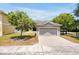 Inviting one-story home with a brick driveway, mature trees, and a charming architectural facade at 14522 Old Thicket Trace, Winter Garden, FL 34787