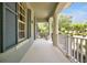 Spacious front porch with white railings and columns, offering a view of the landscaped yard at 14522 Old Thicket Trace, Winter Garden, FL 34787