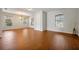 An open concept living room with wood floors, large windows, and a hanging chandelier at 14522 Old Thicket Trace, Winter Garden, FL 34787