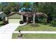Charming one-story home with stone accents, a two-car garage, and a lush landscaped front yard at 1512 Southwind Ct, Casselberry, FL 32707