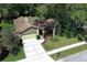 Aerial view of a well-maintained home with lush landscaping and a driveway at 1512 Southwind Ct, Casselberry, FL 32707