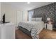 Bedroom features decorative wallpaper, and a Queen bed with matching bedside tables and closet at 1571 Palmero Way, Davenport, FL 33896