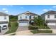 Charming two-story home with a two-car garage, lush landscaping, and a brick driveway at 1571 Palmero Way, Davenport, FL 33896