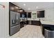 Modern kitchen featuring dark cabinetry, stainless steel appliances, and sleek countertops at 1571 Palmero Way, Davenport, FL 33896