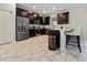 Stylish kitchen with stainless steel appliances, dark cabinets, and a breakfast bar for casual dining at 1571 Palmero Way, Davenport, FL 33896