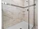Close up of the glass enclosed shower featuring marble styled tile, and a built-in soap shelf at 1571 Palmero Way, Davenport, FL 33896