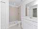 Bright bathroom with a tiled shower, vanity with sink, and modern fixtures at 1649 Teagan Ln, Winter Haven, FL 33884
