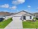 Charming one-story home featuring a gray roof, well-maintained lawn, and a two-car garage at 1649 Teagan Ln, Winter Haven, FL 33884