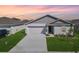 Charming one-story home featuring a gray roof, well-maintained lawn, and a two-car garage at 1649 Teagan Ln, Winter Haven, FL 33884