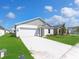 A well maintained lawn and landscaping of a one-story home with a two-car garage and concrete driveway at 1649 Teagan Ln, Winter Haven, FL 33884