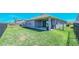 Backyard with a well-maintained lawn, black iron fence, and a covered patio at 18851 Rawson St, Orlando, FL 32827