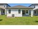 A view of the property's backyard and sliding glass door with access to the covered patio at 1900 Archer Dr, Minneola, FL 34715