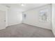 A bright bedroom featuring carpet floors, white walls and two windows at 1900 Archer Dr, Minneola, FL 34715