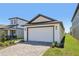 Charming home with a white garage door and an inviting paver driveway and walkway at 1900 Archer Dr, Minneola, FL 34715