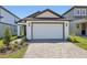 Charming home with a white garage door and an inviting paver driveway and walkway at 1900 Archer Dr, Minneola, FL 34715