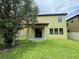 Large backyard with green grass, mature shade tree, and covered porch at 191 Chickasaw Berry Rd, Ocoee, FL 34761