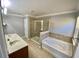 A spacious bathroom with double sinks, garden tub and tiled walk-in shower with glass doors at 191 Chickasaw Berry Rd, Ocoee, FL 34761