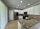 Modern kitchen with stainless steel appliances, granite countertops, and white cabinetry at 191 Chickasaw Berry Rd, Ocoee, FL 34761