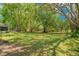 Large backyard with mature trees, a wooden fence, and ample green space perfect for outdoor activities and relaxation at 20 Stone Gate S, Longwood, FL 32779