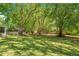 Spacious backyard with mature trees, swimming pool, screened-in porch, and a rustic fence, creating a serene atmosphere at 20 Stone Gate S, Longwood, FL 32779