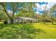 Traditional home with a well-manicured lawn, mature trees, and a welcoming facade at 20 Stone Gate S, Longwood, FL 32779