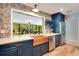 Kitchen area with blue cabinets, a copper sink, stainless steel appliances, and a pass-through window to the dining room at 20 Stone Gate S, Longwood, FL 32779