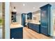 Charming kitchen featuring blue cabinets, modern appliances, stone backsplash, wood floors, and ample counter space at 20 Stone Gate S, Longwood, FL 32779