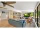 Open-concept living room featuring a view of the game room, pool, brick accents, and comfortable seating at 20 Stone Gate S, Longwood, FL 32779