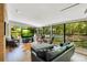 Bright living room with a wall of windows overlooking the pool and backyard, wood floors, and comfortable seating at 20 Stone Gate S, Longwood, FL 32779
