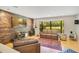 Cozy living room with a featured custom wood wall, leather seating, and natural light through large windows at 20 Stone Gate S, Longwood, FL 32779
