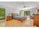 Spacious main bedroom featuring hardwood floors, a ceiling fan, and sliding doors leading to the pool area at 20 Stone Gate S, Longwood, FL 32779